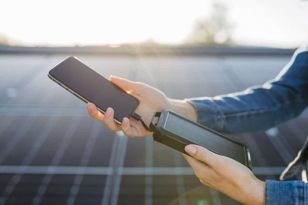 Woman using a solar panel to charge a battery directly.
