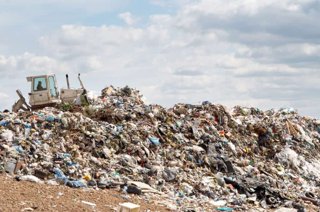 Photograph of discarded solar batteries piled up in a landfill, representing the environmental impact of improper disposal and highlighting the need for responsible e-waste management.