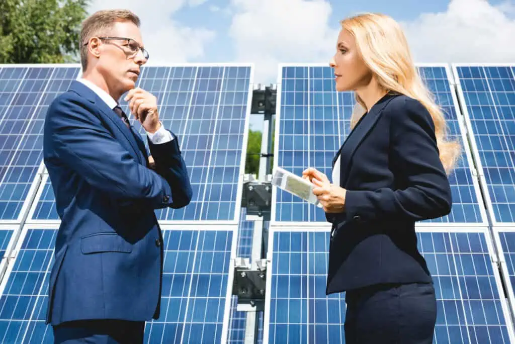 Man and woman discussing the role of the government in using solar power to replace fossil fuels.