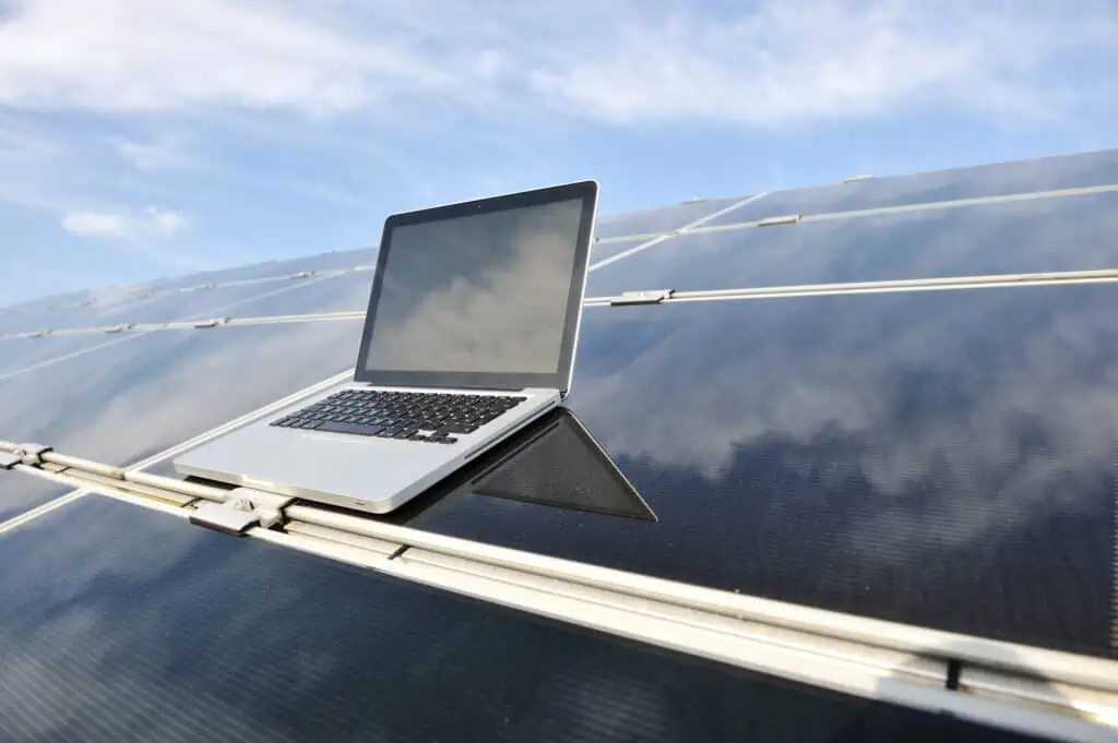 Laptop on photovoltaic panel proving that solar panels can power your computer.