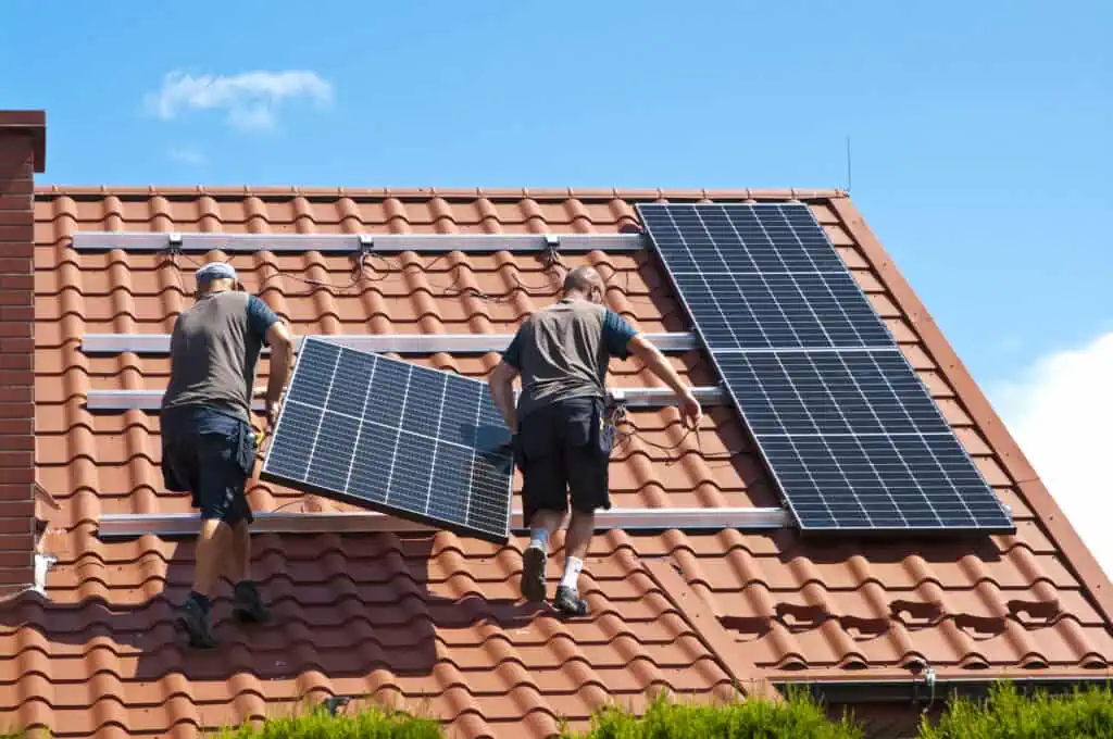 Experts installing a solar panel system on a house.